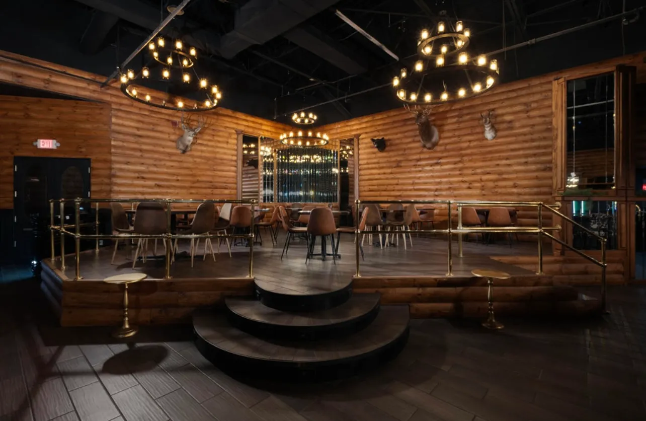 The log-cabin dining room under wagon-wheel chandeliers