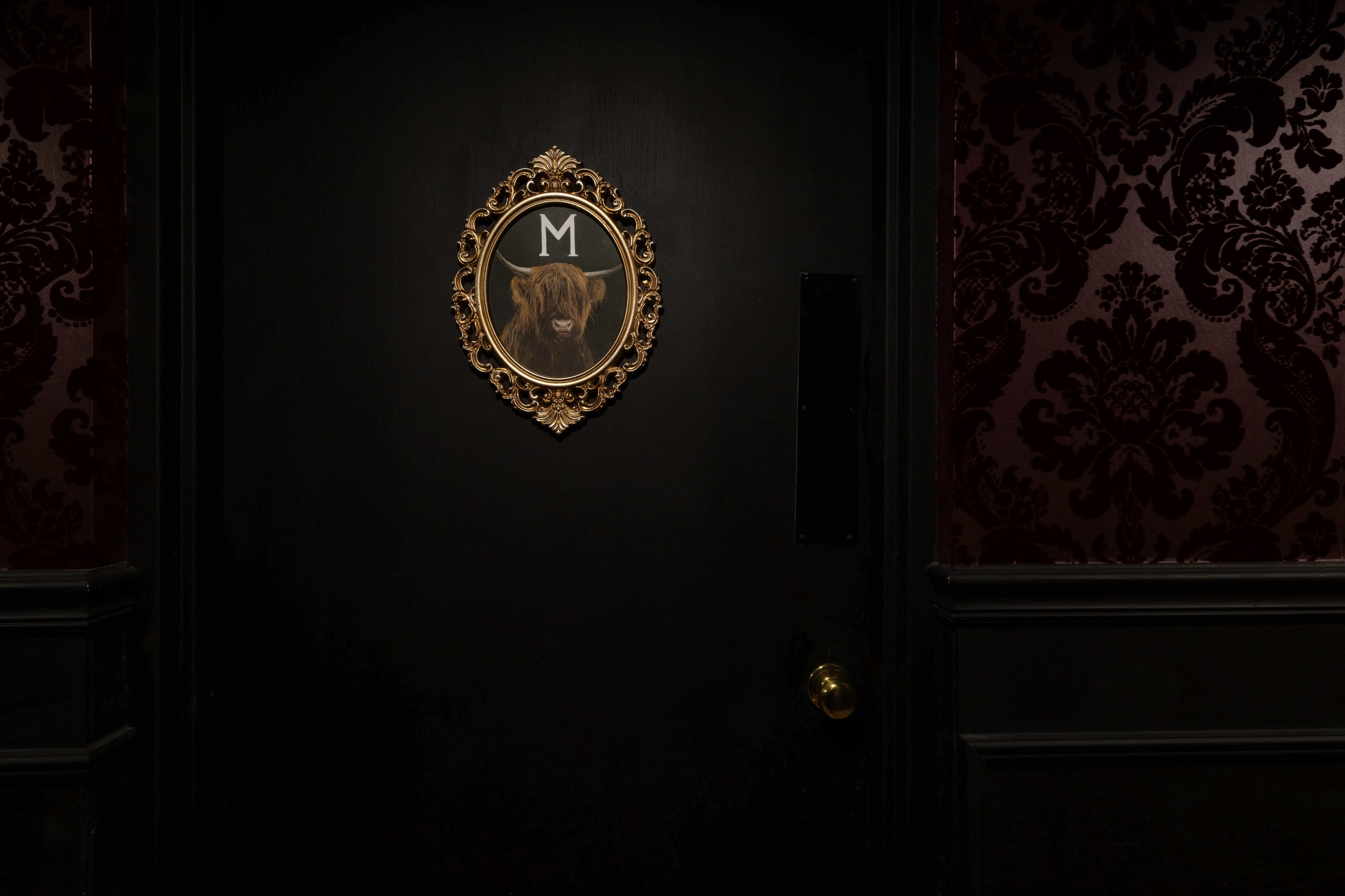 The Western Horseman Club door: a gilded portrait of a highland bull on black