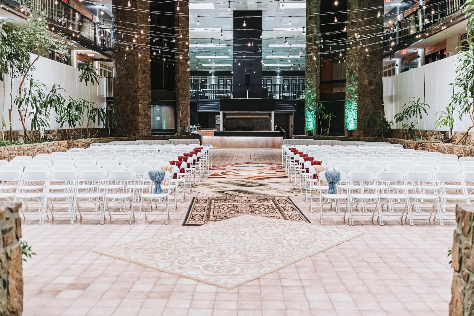 Rows of white chairs set for an atrium ceremony