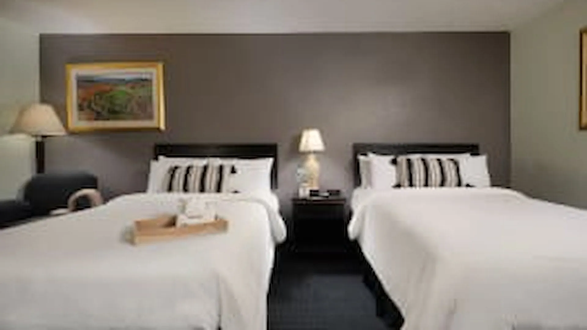 Basic double room with two beds and framed artwork