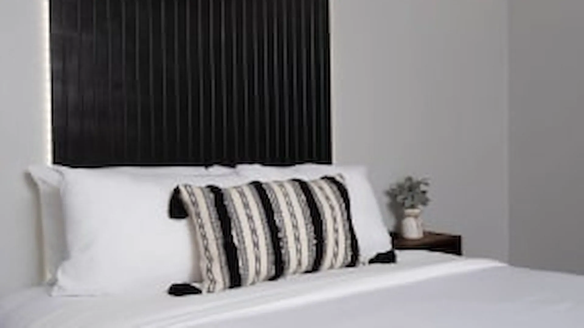 Deluxe suite bedroom with dark headboard wall